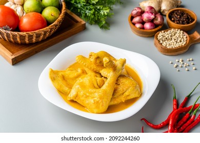 Indonesian Traditional cuisine : Ayam Gulai Padang. Ayam Gulai is a popular dish of chicken curry from Padang, West Sumatra. served on plate and isolated on gray background.