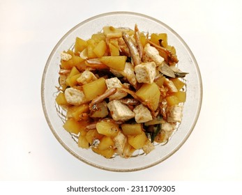 Indonesian traditional dish named "tumis tahu kentang teri cabe hijau" that is stir-fried tofu, potatoes and green chili anchovies served on a plate, isolated on a white background - Shutterstock ID 2311709305