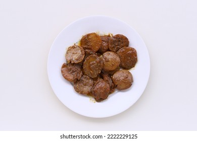 Indonesian traditional food named "semur jengkol" i.e. djenkol cooked with spices and soysauce served on plate isolated on white background