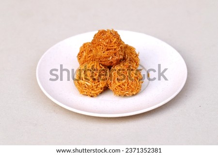 Indonesian traditional snack named 'grubi' i.e. grubi made from thin slices cassava cooked with palm sugar and rounded shaped, served on plate isolated on white background Zdjęcia stock © 