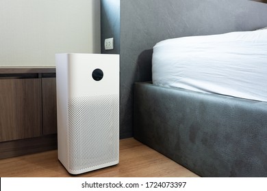 Indoor air purifier with digital monitor screen in bedroom locate side bed, that show air quality in the room. PM 2.5 is a major environmental health problem affecting everyone.