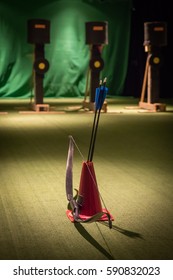 Indoor Archery Range, Bow And Three Green Fletched Arrows Stand Ready For Shooting, With Three Targets Behind