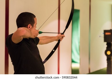 Indoor Archery Range, Single Man Aiming Drawn Bow With Arrow Towards Targets