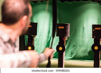 Indoor Archery Range, Single Man Aiming Drawn Bow With Arrow Towards Targets