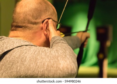 Indoor Archery Range, Single Man Aiming Drawn Bow With Arrow Towards Targets