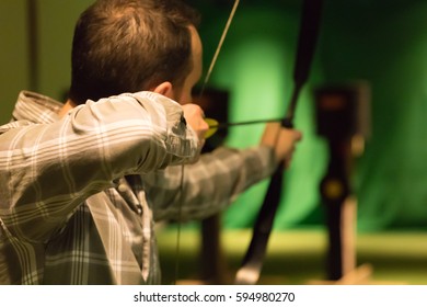 Indoor Archery Range, Single Man Aiming Drawn Bow With Arrow Towards Targets