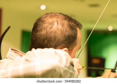 Indoor Archery Range, Single Man Aiming Drawn Bow With Arrow Towards Targets