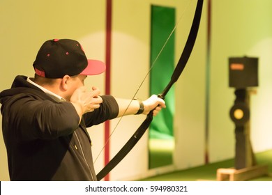 Indoor Archery Range, Single Man Just Loosed An Arrow From Bow In Front Of Targets