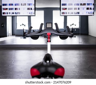 Indoor Bike With Blurred Background Of Tv Screen, Depth Of Field. Empty Cycling Class With Steaming Training Technology, Exercise For Cardio And Healthy. Work Out Equipment In Gym, Healthy Lifestyle.