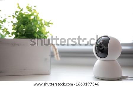 Indoor CCTV wireless IP security camera with 360 degrees rotating head, Concept of home security system for surveillance and protection, controlling via smartphone online.