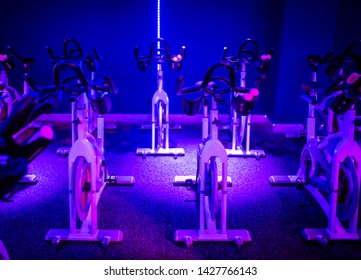 An Indoor Cycling Dance Bike In A Blue LED Lighting Room With Cycling Equipments