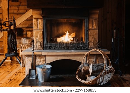 Indoor Fireplace Safety. How to Safely Use and Maintain a Wood-Burning Fireplace. Fireplace, wicker basket for firewood, pile of logs for a fire