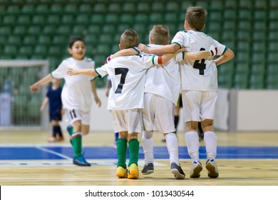 Indoor Football Soccer Match For Children. Happy Kids Together After Winning Futsal Game. Children Celebrate Sport Victory. Youth Sport Triumph In Futsal. Futsal Indoor Soccer Tournament For Kids