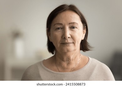 Indoor head shot portrait of serious positive old mature woman in casual looking at camera, posing at home, promoting retirement, elderly healthcare. Senior grandmother woman video call screen - Powered by Shutterstock