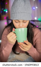 Indoor Image Of An Asian, Indian Beautiful, Happy Young Woman Looking Up And Contemplating While Drinking And Holding A Cup Of Coffee In Winter Season At Home. She Is Wearing Warm Clothes.