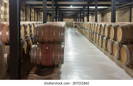 Indoor photo of many wooden barrels in  winery