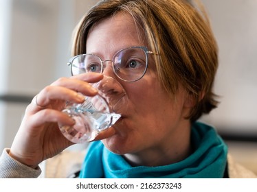 Indoor Portrait Of A 35 Year Old Woman Drinking A Glass Of Water