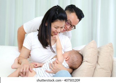 Indoor Portrait Of Asian Mother Breastfeeding Her Baby