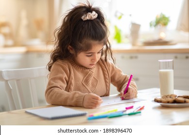 Indoor Portrait Of Small Adorable Girl Drawing Picture At Table In Kitchen, Cute Female Child Doing Homework, Enjoying Domestic Leisure And Kids Development Activities, Free Space - Powered by Shutterstock