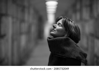 Indoor Portrait Of A White Woman, Eyes Closed, Looking Up In A Warehouse