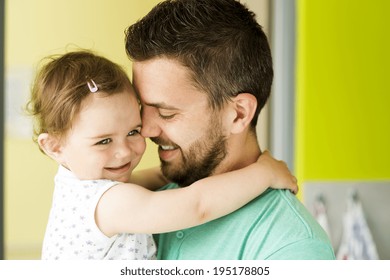 Indoor portrait of young father hugging his little daughter - Powered by Shutterstock