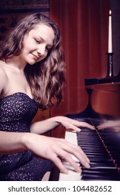 Indoor Portrait Of A Young Female Piano Player