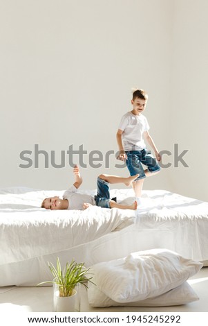 Image, Stock Photo Relaxed mother and sons playing over the bed
