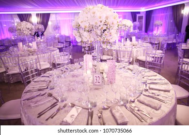 Indoor round reception table with flowers and chairs