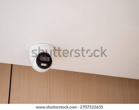 Indoor security camera mounted on ceiling in modern building, representing surveillance system, safety monitoring, CCTV installation, and smart security technology for home or business protection.