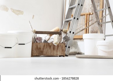 Indoor Shot Close Up Frontal View Of Bricklayer, Plasterer Or House Painter Tools On White Floor With Buckets In Home Renovation Site