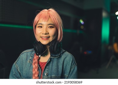 Indoor Shot In A Dark Room Of A Cute Pretty Asian Gamer Girl With Long Pink Braid, Wearing Denim Jacket . High Quality Photo