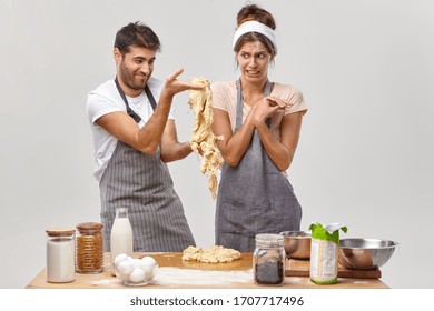 Indoor Shot Of Man Failed To Make Dough, Did Something Not According To Recipe, Learns To Cook, Frustrated Wife Looks With Disgust, Has Face Covered With Flour. Cooking Skill, Family Recipe.