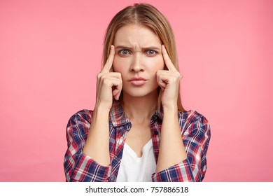 Indoor shot of pensive female model tries to concentrate or remember important information, had bad memory, has thoughtful expression. Female student answers on exam, recollects topic in mind - Powered by Shutterstock