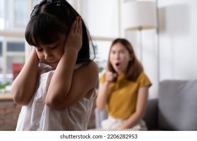 Indoor Shot Of Young Asian Girl Crying And Cover Her Ear With Hands And Feel Sad While Get Scold And Shout With Angry From Her Angry Mother. Child Abuse That Can Cause A Problem For Children.