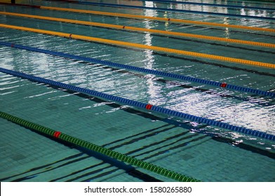 Indoor Swimming Pool. Ropes Divide The Swimming Lanes Of An Indoor Pool Ahead Of A Swim Meet Inside A Sports Arena           