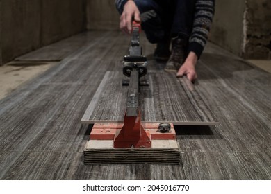 Indoor tiler cuts floor gray tiles 