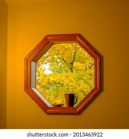 Indoor View Of Autumn Leaves Through Octagonal Window On Rainy Fall Day