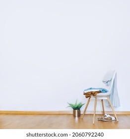 Indoors flat wall mockup with green potted houseplant and Clothes over Chair in minimalist style. Earthy Neutrals Tones Background. Interior in airy light style with wooden floor - Shutterstock ID 2060792240