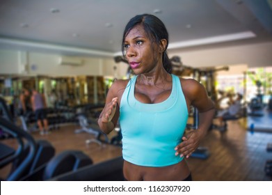 indoors gym portrait of young attractive black afro American woman training hard all sweaty at fitness club a treadmill running workout in body care and runner healthy lifestyle concept - Powered by Shutterstock