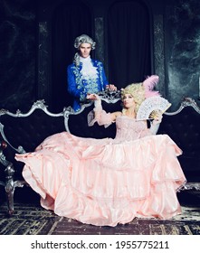 Indoors shot of a beautiful young marquise in the Marie Antoinette style with her partner in the palace