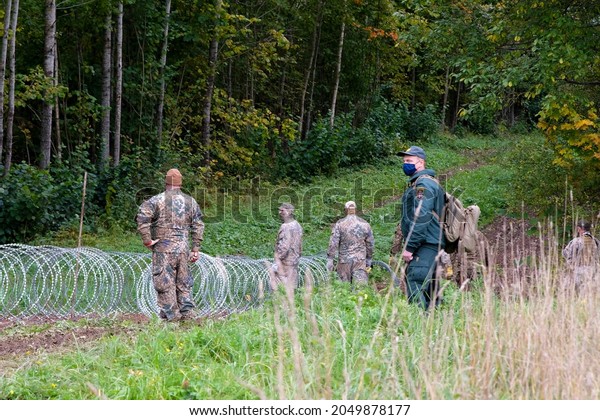 Indra, Latvia - September 28, 2021: Latvia -\
Belarus border, where Latvian State Border Guard and army begins to\
install a barbed wire\
fence
