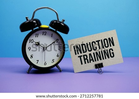 Induction Training text with alarm clock on blue and purple background