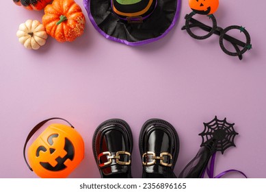 Indulge in Halloween trick-or-treat festivity with this bird's-eye top view photo featuring witch costume and Halloween ornaments on purple isolated backdrop, ideal for adverts or text incorporation