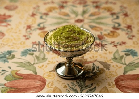 Indulging in a charming dessert at a classy eatery, this delightful treat showcases layers of flavor and vibrant colors. The intricate design of the table adds to the dining experience