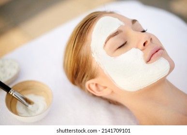 Indulging In A Deep Cleansing Masque. Shot Of A Young Woman Getting A Facial At A Spa.