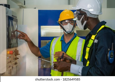 industrail background of factory workers wearing face mask to protect coronavirus covid-19 with safety vest and helmet having working detail brief from factory foreman in control room