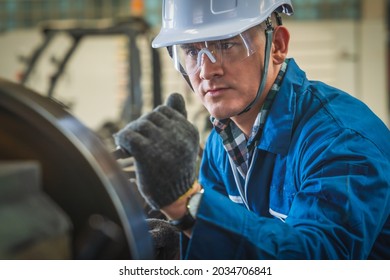 Industrail background of portrait of mechanic engineer operating lathe machine to make metal part in metalwork workshop and factory