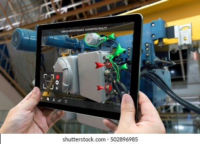 Industrial 4.0 , Augmented reality concept. Hand holding tablet with AR service , maintenance application and calling technician for check destroy part of smart machine in smart factory background - Shutterstock ID 502896985