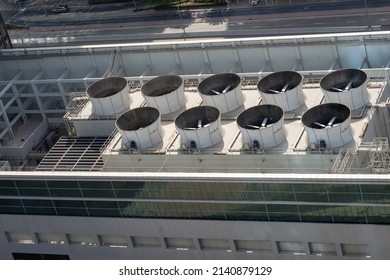 Industrial air conditioning system on the roof of the building. Evaporators with propellers of the ventilation system. Technical upper floor of a modern technological building with stairs.