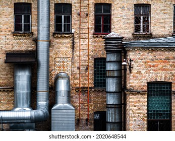 Industrial Architecture: Brick Factory Wall With Metallic Chimneys.